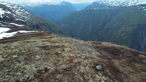 Luftaufnahme-Eines-Einsamen-Erwachsenen-Mannes,-Der-Auf-Der-Kante-Des-Voringsfoss-In-Norwegen-Steht