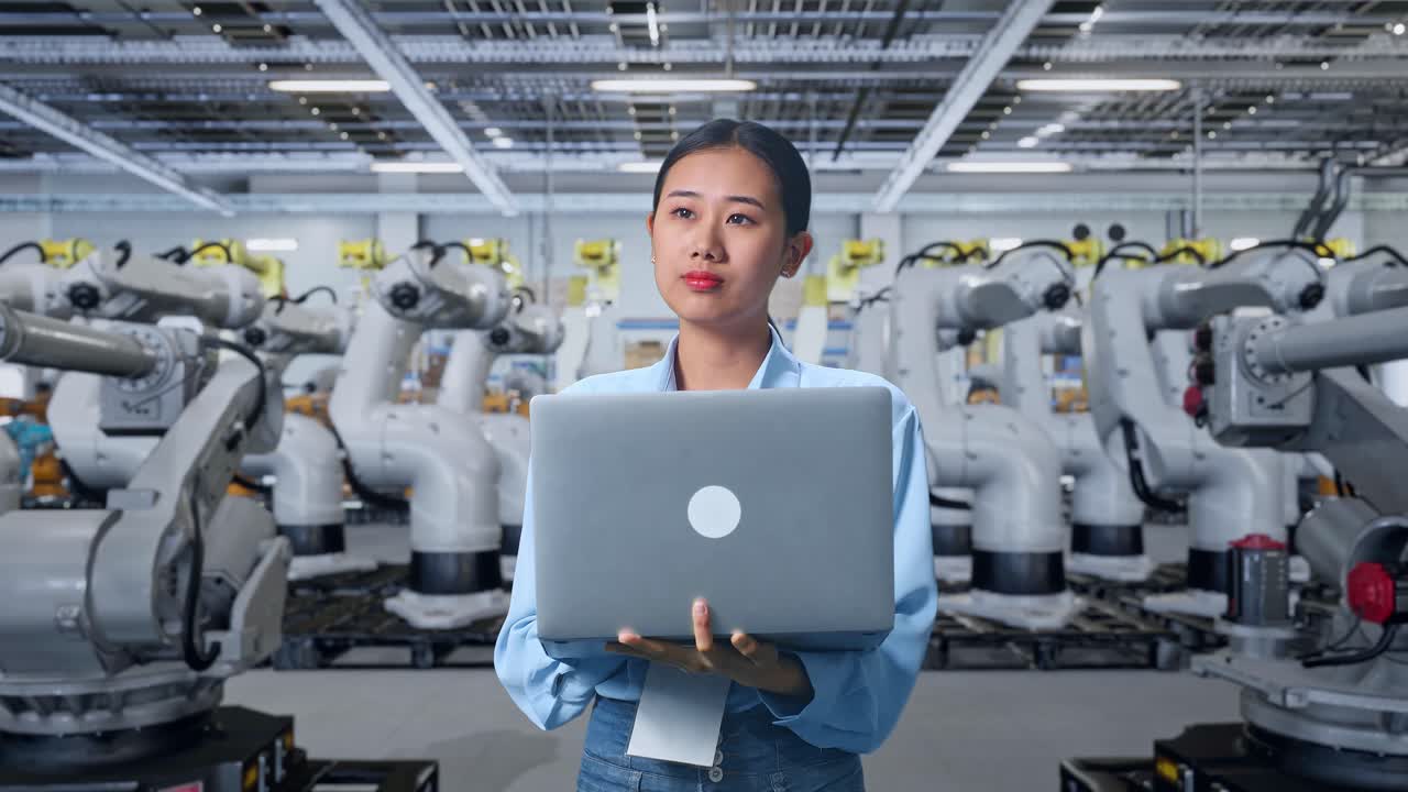 Woman Engineer Working with Robots in a Factory