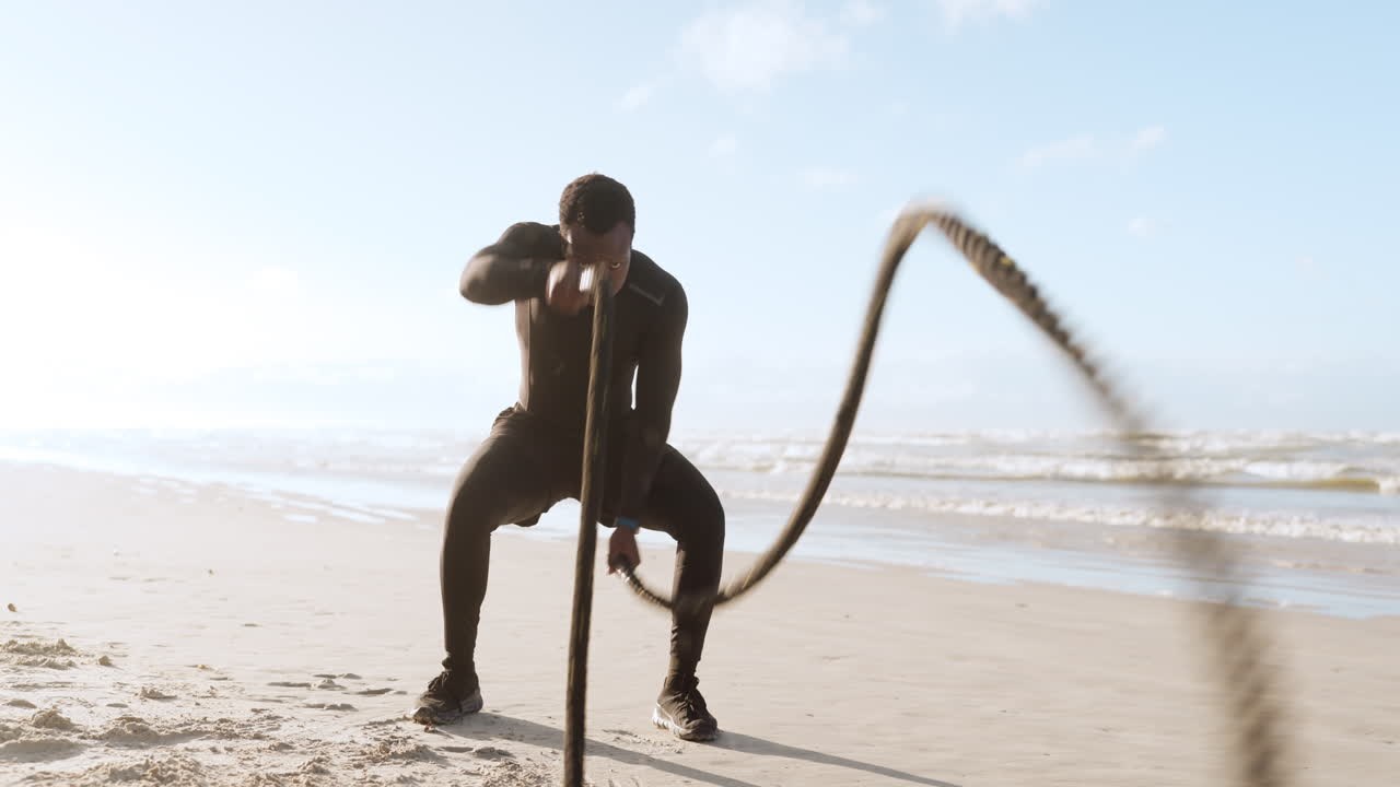 Beach, battle rope and black man with exercise