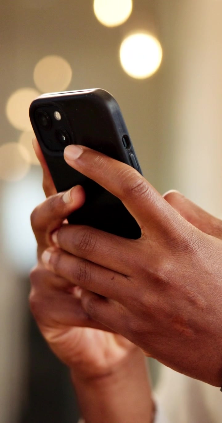 Nærbillede af person, der bruger smartphone i lyse omgivelser