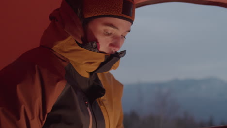 woman using laptop in camping tent in winter