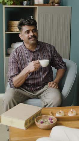 a man drinking tea indoors