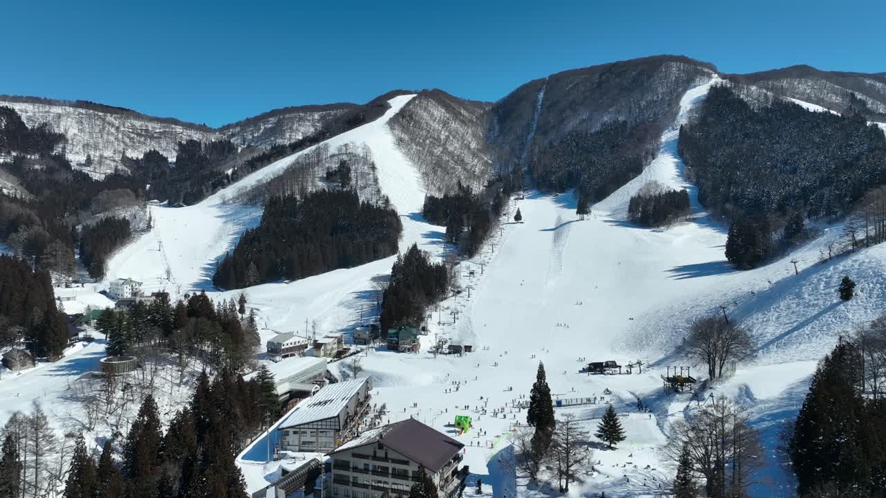 스키 경로 아래쪽의 정적, 스키 선수들이 산의 바닥에 도착하여 의자 엘리베이터를 위해 줄을 서 있습니다.
