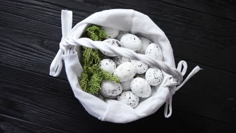 quail eggs in a nest on a black rustic wooden background  easter symbols