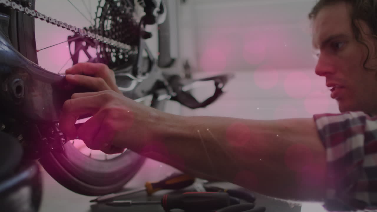 animación de formas que se mueven sobre un hombre caucásico reparando una bicicleta