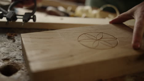 unrecognized man making pattern on wood indoors. carpenter finishing product