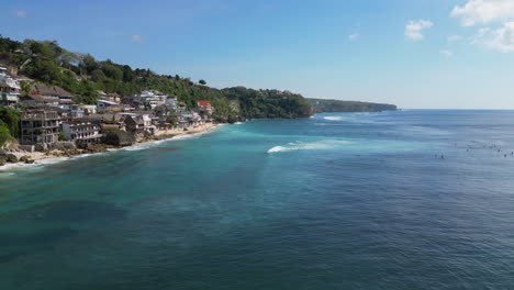 blue waves roll in against uluwatu coastline in bali indonesia