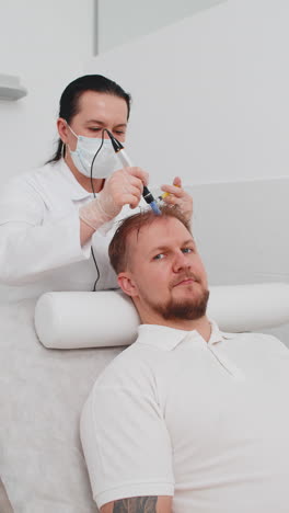 trichologist doing man improve hair growth procedure dermapen microneedling vitamin injections
