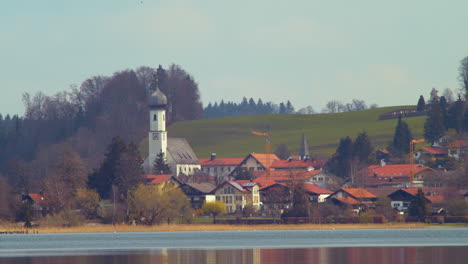 Closeup-shot-of-Gmund-and-its-church-from-the-other-side-of-the-Tegernsee