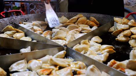 street food. fried pierogi - polish dish, prepared by a chef in a deep skillet to perfection