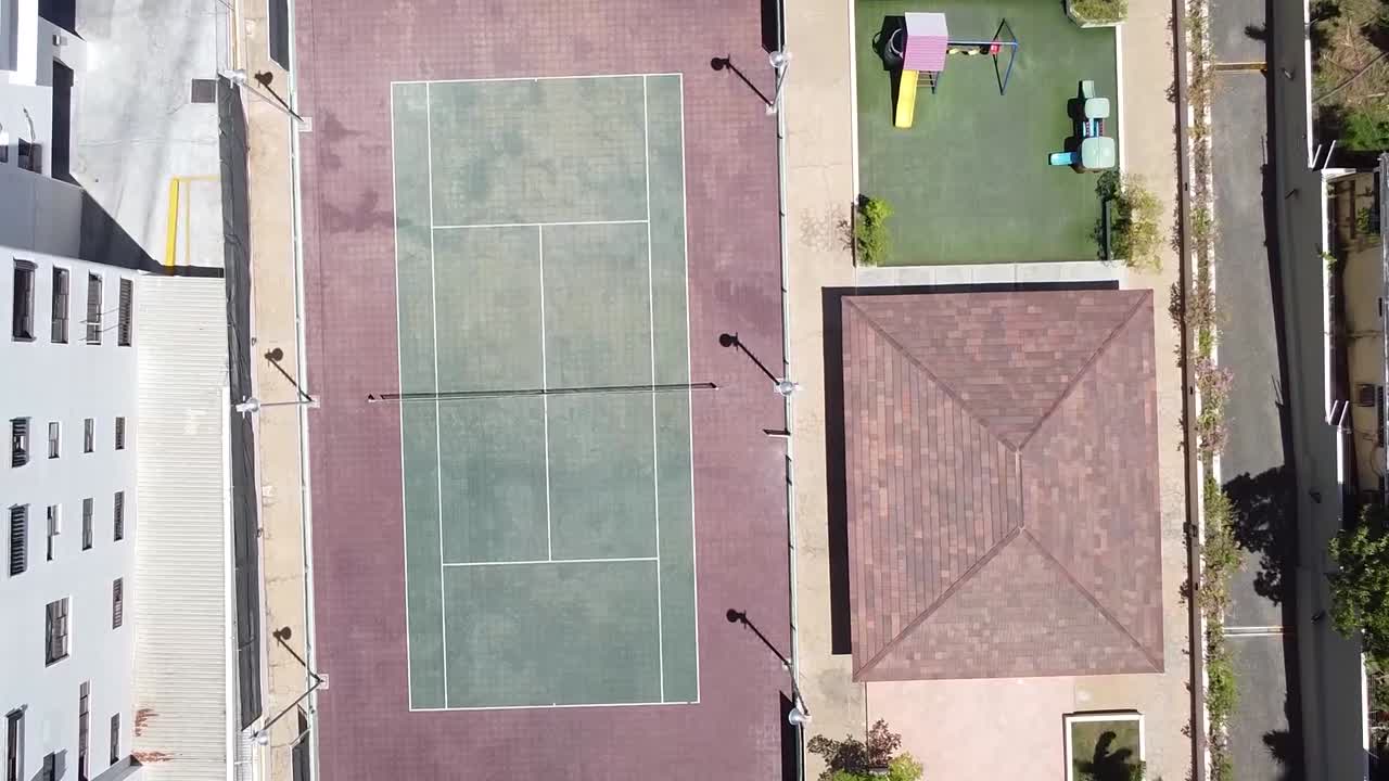 видео с беспилотника над теннисным кортом в жилом районе, спортивный стиль жизни
