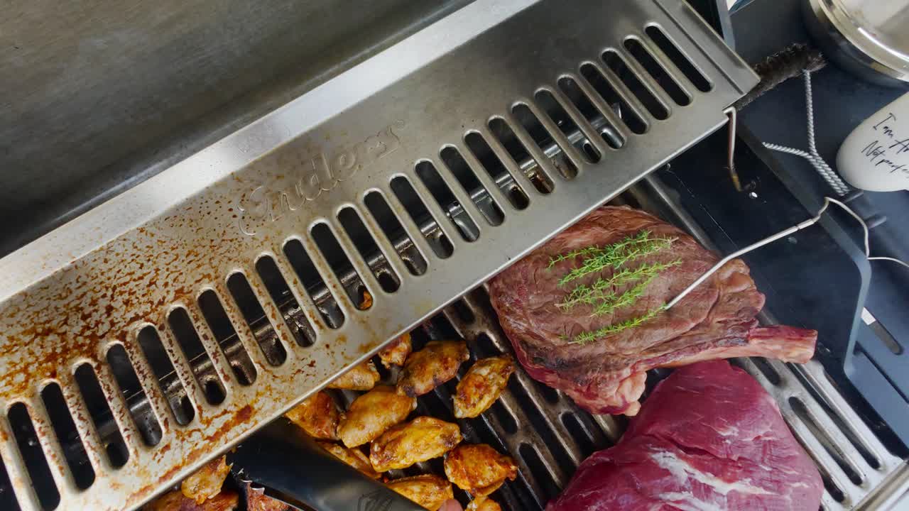 Steaks and wings grilling outdoors, summer BBQ vibes