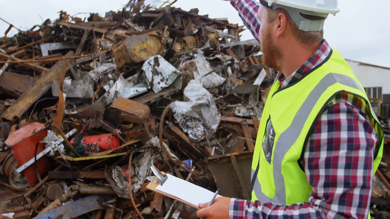 trabajador masculino que trabaja en el depósito de chatarra 4k