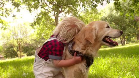 happy child pets a labrador retriever dog at park