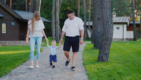 mamá y papá caminando con un hijo pequeño