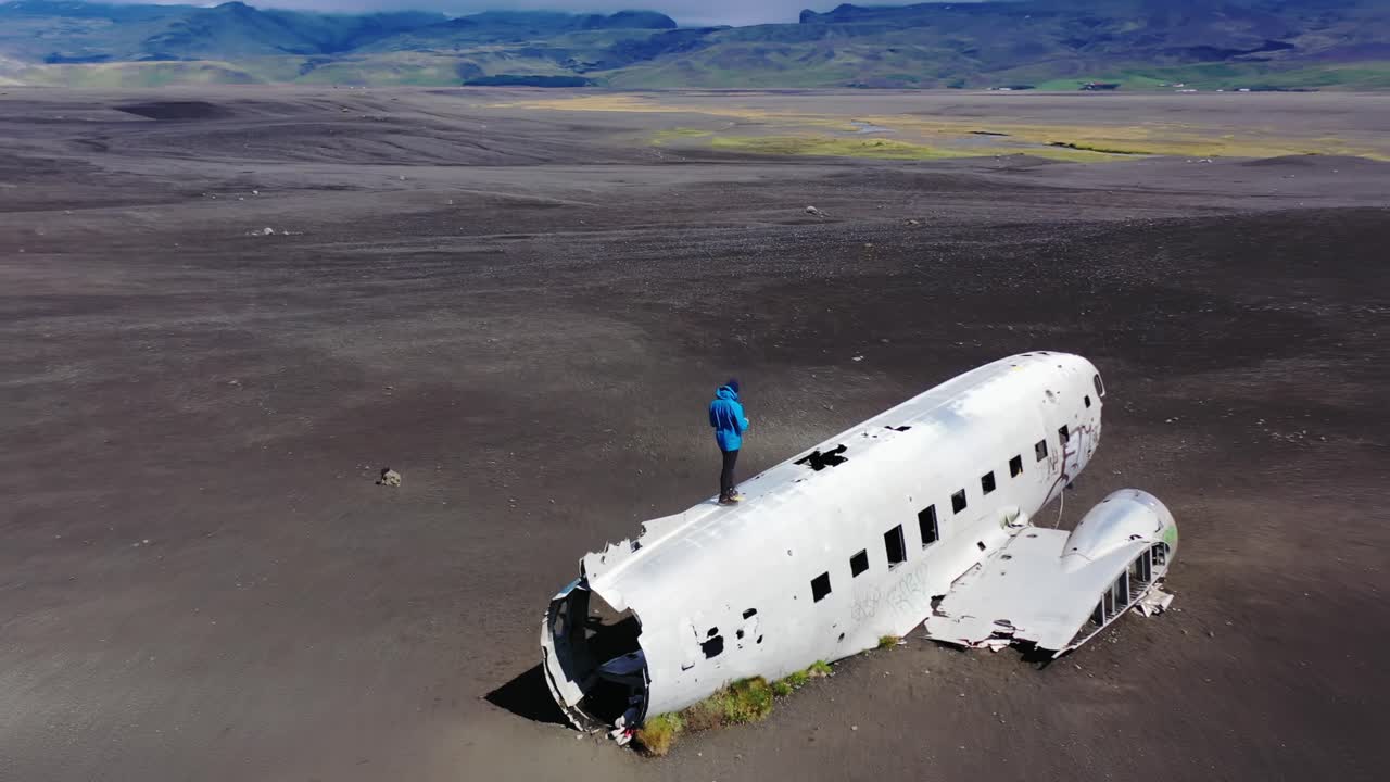 hombre de pie en un avión naufragado en islandia