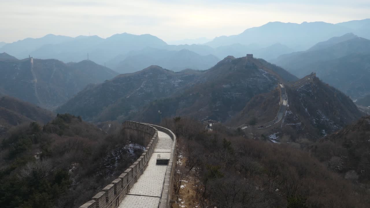 Experience a captivating slow motion reveal capturing the stunning landscape from a window along the Great Wall of China, showcasing its ancient beauty and the surrounding mountains.