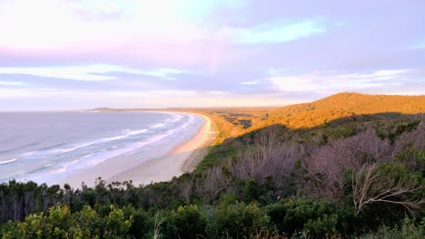 quiet and empty beach of crescent head - mountain view with colorful sky during sunrise - sydney, nsw, australia