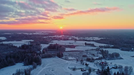 Puesta-De-Sol-Sobre-Un-Paisaje-Nevado,-Cielos-Vibrantes,-Anochecer-Invernal,-Vista-Aérea