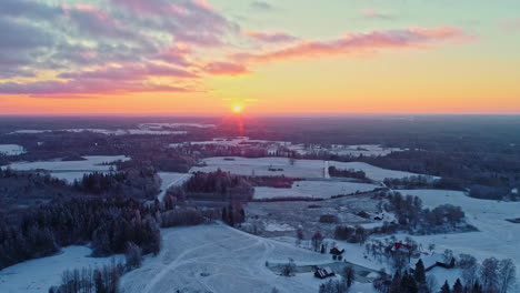 puesta de sol sobre un paisaje nevado, cielos vibrantes, anochecer de invierno, vista aérea