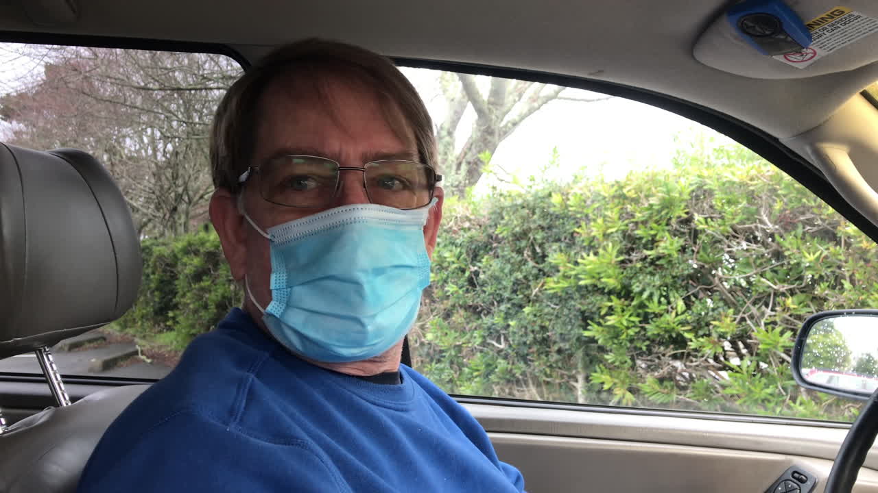 hombre con mascarilla sale del auto con cartas - toma manual