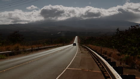 una minivan viaja a lo largo de un camino solitario hacia el desierto