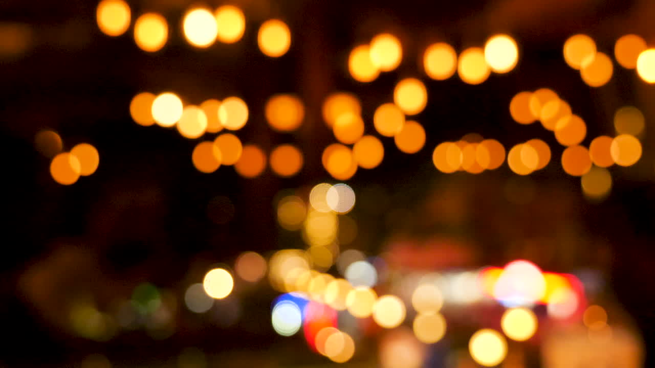 Zoom in on light bokeh defocused over a dark background