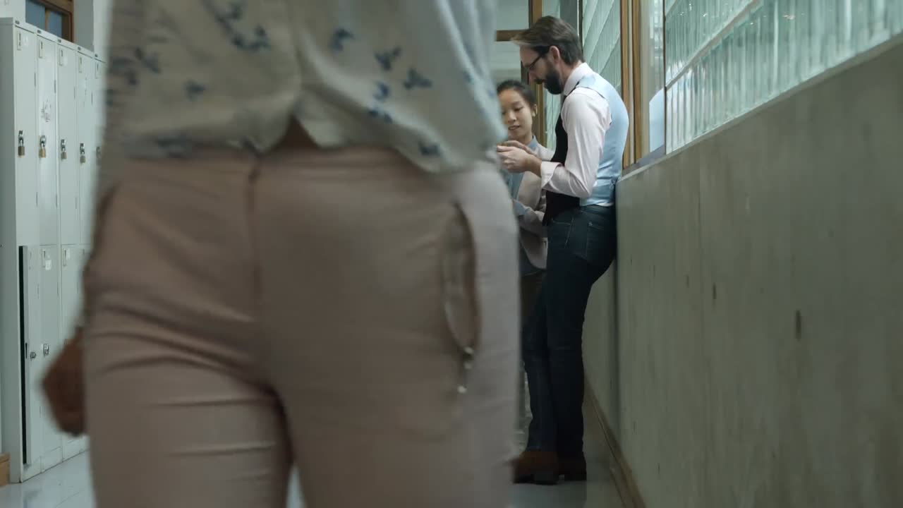 colegas discutiendo sobre una tableta digital en el corredor 4k