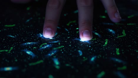 exploring biological microorganisms: a close-up visual journey of glowing bacteria under touch, revealing vibrant interactions and unique patterns