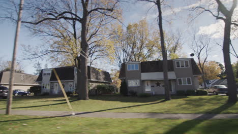 side view: drive through a typical american suburb on a clear autumn day