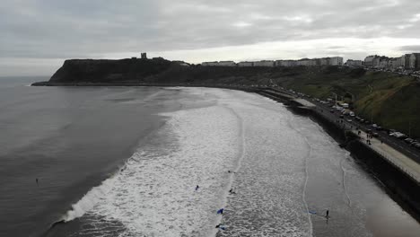 Surfers-enjoying-the-waves-in-Scarborough,-Yorkshire,-UK