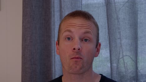 face portrait of a healthy man eating meat with a fork, showing enjoyment and satisfaction while chewing