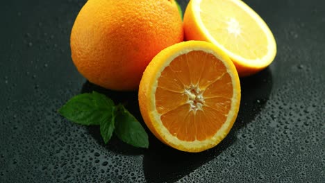naranja con hoja sobre mesa mojada