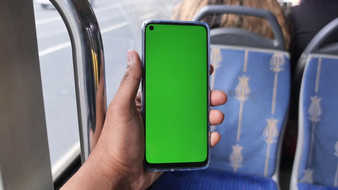 persona sosteniendo un teléfono inteligente con pantalla verde en un autobús
