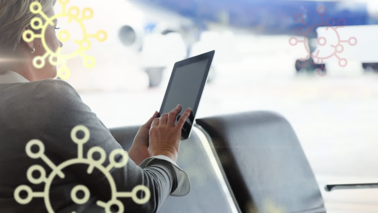 animación de iconos de células de covid-19 flotantes sobre una mujer caucásica que usa una tableta en el aeropuerto