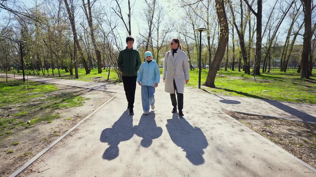 Famiglia a passeggio in un parco in una giornata di sole