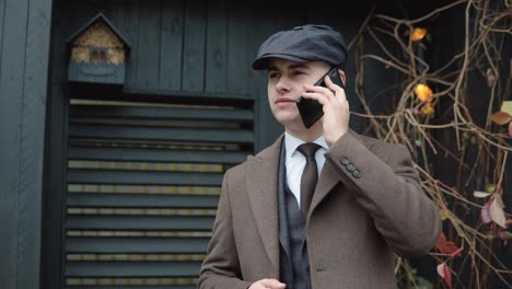 elegant smiling businessman talking on the phone on street. businessman talking mobile phone in the city. portrait of a handsome man having a phone talk outdoors