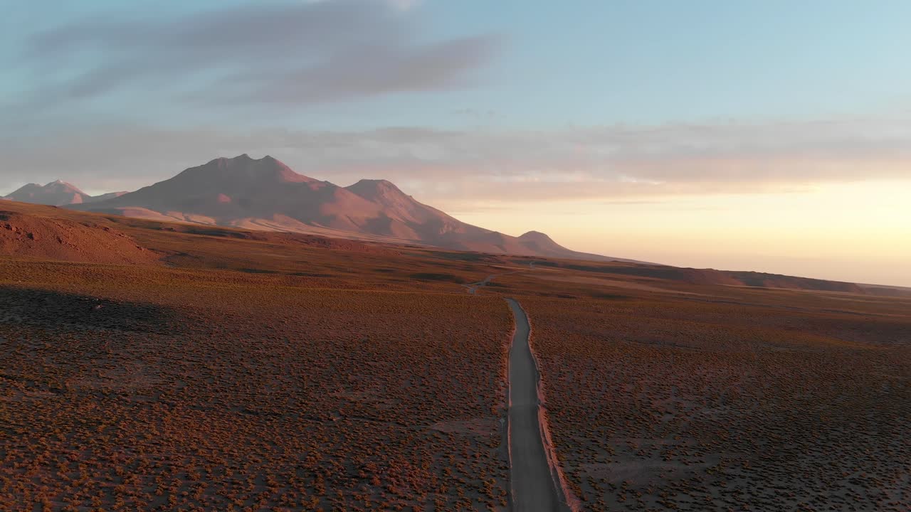 Ripresa con drone di una strada sterrata al tramonto nel deserto di Atacama, Cile, Sud America