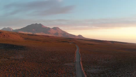 drone shot of a dirt road at sunset in the atacama desert, chile, south america