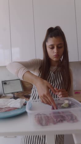 woman preparing fish in kitchen