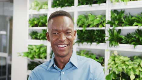 Portrait-of-happy-african-american-businessman-looking-at-camera-and-smiling-at-office,-slow-motion