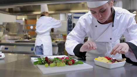 cook at a counter making a fruit salad