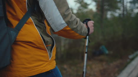 Closeup-view-of-hiker-walking-through-forest-on-wooden-path