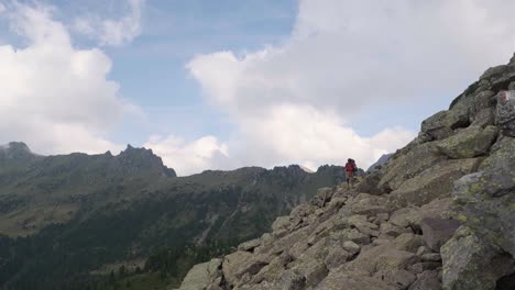 Excursionista-Masculino-Con-Bastones-De-Senderismo-Escalando-En-Un-Peligroso-Acantilado-De-Montaña-Durante-El-Día-Soleado-En-La-Cadena-Montañosa-Lagorai