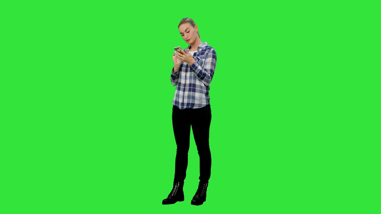 Tired working young woman reading messages on the phone on a Green Screen, Chroma Key