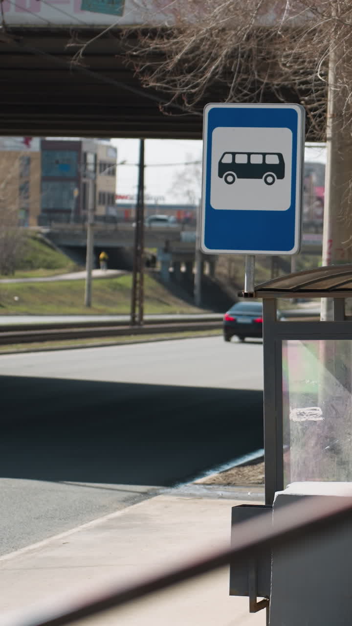 도시 환경에서 버스 정류장 표지판과 함께 지나가는 두 사람의 가까운 시각.