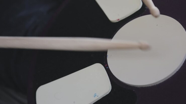 A Beginner Practicing Drumming By Slowly Striking The Drumhead In Tempo - Close Up Shot