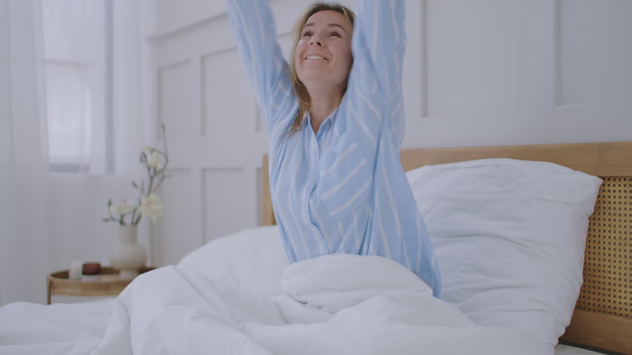 una mujer de negocios haciendo una videollamada en un hotel. una chica feliz se acuesta en la cama y habla con sus amigos a través de una videoconferencia.