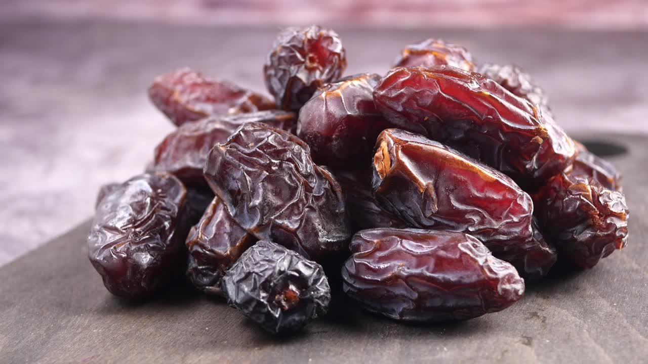 Pile of Dried Dates on a Dark Wooden Board