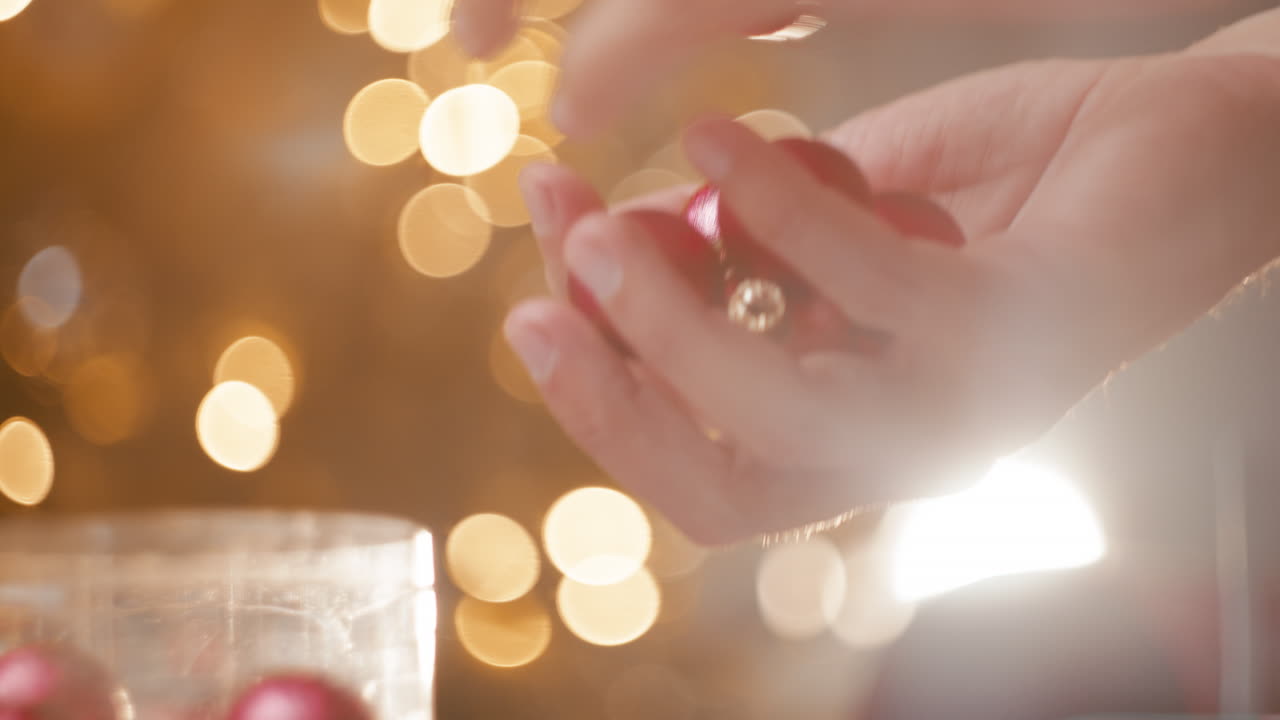 Small red Christmas ornaments held by a man